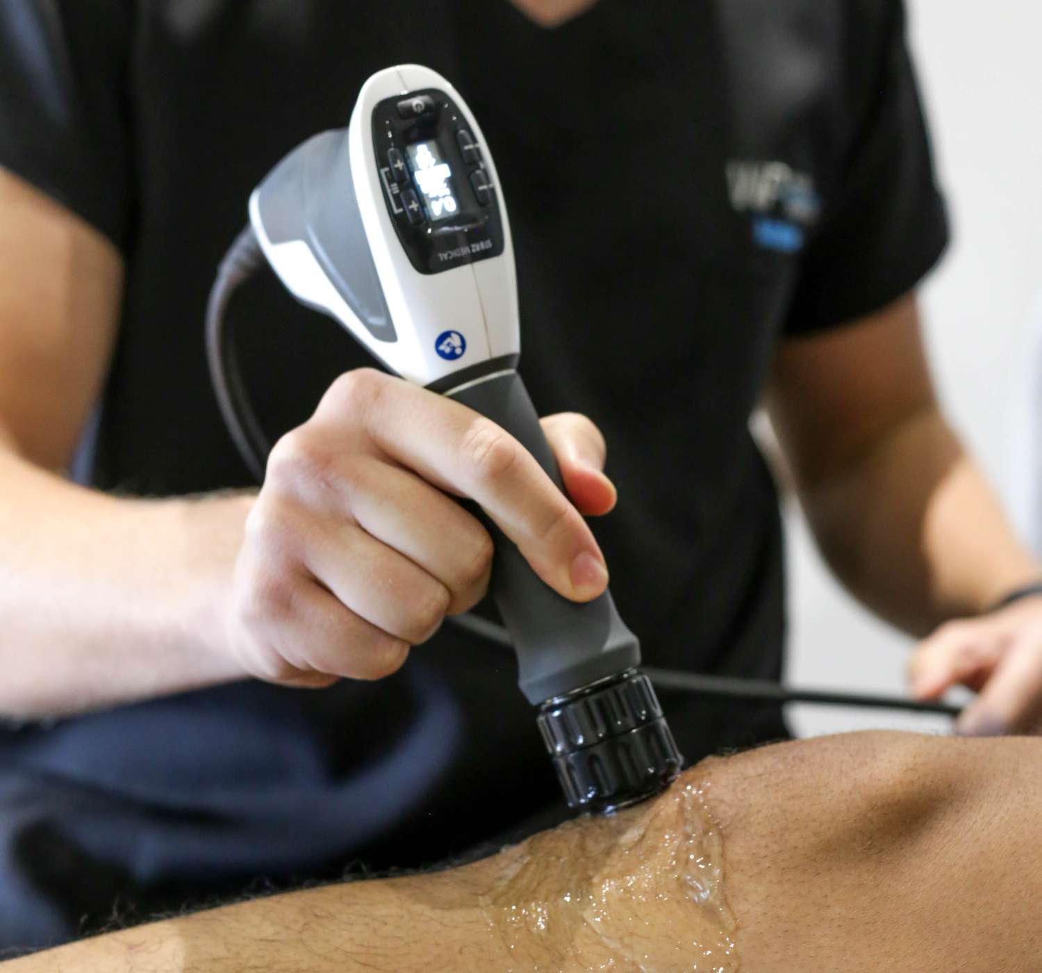 Shockwave therapy device being applied to a patient's shoulder